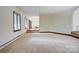 Bright living room featuring neutral carpeting, large windows, and seamless flow to the foyer at 695 Knollcrest Ne Dr, Concord, NC 28025