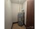 Water heater beside a door on a floor with patterned tiles, installed in a small room at 695 Knollcrest Ne Dr, Concord, NC 28025