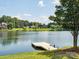 Picturesque lake view featuring a private dock, mature trees, and distant homes in a tranquil setting at 705 Congressional Ln, Fort Mill, SC 29708