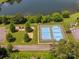 Overhead view of blue tennis courts, playground, parking, and lush greenery near a lake at 705 Congressional Ln, Fort Mill, SC 29708
