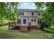 Exterior of the house featuring a deck, staircase, lawn, and mature trees at 7114 Kinsmore Ln, Charlotte, NC 28269