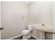 Neat powder room featuring a pedestal sink, toilet, and neutral color palette at 7114 Kinsmore Ln, Charlotte, NC 28269