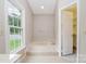 A relaxing bathroom featuring a sunken tub and natural light from the window at 7114 Kinsmore Ln, Charlotte, NC 28269