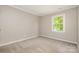 Cozy bedroom with neutral tones, carpet flooring, and a window for natural light at 7114 Kinsmore Ln, Charlotte, NC 28269