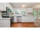 Well-equipped kitchen featuring white cabinets, stainless steel appliances and wood floors at 7114 Kinsmore Ln, Charlotte, NC 28269