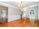 Bright living room showcasing hardwood floors, decorative molding and a view into the adjacent room at 7114 Kinsmore Ln, Charlotte, NC 28269