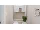 Cozy powder room with a silver framed mirror, open shelf, and decorative plant at 7121 Bidford Ct, Indian Land, SC 29707
