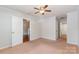 Cozy bedroom featuring a ceiling fan, neutral carpet, and an adjoining bathroom and closet at 7121 Bidford Ct, Indian Land, SC 29707