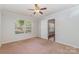 This carpeted bedroom features a large window for natural light and a ceiling fan for added comfort at 7121 Bidford Ct, Indian Land, SC 29707