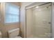 Bathroom with shower and toilet next to a window with blind at 7320 Ritter Dr, Charlotte, NC 28270