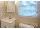 Bathroom featuring a single sink vanity and window with blind at 7320 Ritter Dr, Charlotte, NC 28270