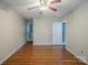 Spacious bedroom with hardwood floors, ceiling fan, and view into the bathroom at 7320 Ritter Dr, Charlotte, NC 28270