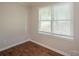 A cozy bedroom featuring wood floors, a window with blinds, and neutral-colored walls at 7320 Ritter Dr, Charlotte, NC 28270