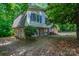 An exterior view of a home with gray and white siding, blue shutters, and surrounded by lush, mature trees at 7320 Ritter Dr, Charlotte, NC 28270
