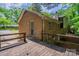 View of the rear exterior of the house, showcasing a wooden deck, brick facade and surrounding greenery at 7320 Ritter Dr, Charlotte, NC 28270