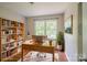 Bright home office with a wooden desk, shelving, and a large window overlooking the yard at 7320 Ritter Dr, Charlotte, NC 28270
