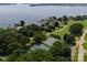 Aerial view showcasing tennis courts, surrounding homes, and water access at 7798 Sand Trap Ln, Stanley, NC 28164