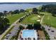 Beautiful aerial shot of pool, golf course, and lake highlighting the many recreational amenities at 7798 Sand Trap Ln, Stanley, NC 28164