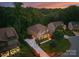Aerial view of the home at dusk, showcasing the well-manicured lawns and mature trees at 7798 Sand Trap Ln, Stanley, NC 28164