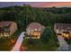 Aerial view of the home at dusk showcasing the roof, landscaping, and surrounding trees at 7798 Sand Trap Ln, Stanley, NC 28164