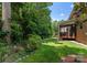 Beautiful backyard featuring a screened-in porch, lush greenery, and a well-maintained lawn at 7798 Sand Trap Ln, Stanley, NC 28164