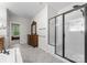 Spacious bathroom with tiled floors, glass shower, and antique vanity at 7798 Sand Trap Ln, Stanley, NC 28164