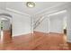 Spacious room with hardwood floors, neutral paint, and an open layout that leads to other rooms at 7798 Sand Trap Ln, Stanley, NC 28164