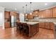 Spacious kitchen featuring stainless steel appliances, a central island, and custom cabinetry at 7798 Sand Trap Ln, Stanley, NC 28164