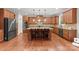 Large kitchen with stainless steel appliances, a central island, and beautiful hardwood floors at 7798 Sand Trap Ln, Stanley, NC 28164