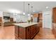 Open-concept kitchen and living room featuring a granite island and stainless steel appliances at 7798 Sand Trap Ln, Stanley, NC 28164