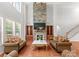 Spacious living room with a soaring stone fireplace, hardwood floors, and built-in bookshelves at 7798 Sand Trap Ln, Stanley, NC 28164
