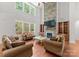 Inviting living room boasts a stone fireplace, large windows, and an open, airy feel at 7798 Sand Trap Ln, Stanley, NC 28164