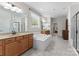 Bright main bathroom featuring double vanities, a soaking tub, and neutral tiling at 7798 Sand Trap Ln, Stanley, NC 28164