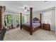 Spacious main bedroom features a four-post bed, multiple windows and ample natural light at 7798 Sand Trap Ln, Stanley, NC 28164