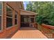 The back of a brick home, featuring a deck and an enclosed porch at 7798 Sand Trap Ln, Stanley, NC 28164