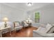 Inviting sitting area with hardwood floors, natural light, and classic furnishings at 7798 Sand Trap Ln, Stanley, NC 28164