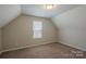 Small, carpeted bedroom features a vaulted ceiling and one window at 8226 Gabon Ct, Charlotte, NC 28215