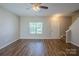 Bright living room with hardwood floors, a ceiling fan, and a staircase leading to the upper level at 8226 Gabon Ct, Charlotte, NC 28215