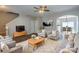 Comfortable living room features modern gray furniture, a ceiling fan, and seamless transition to the dining area at 8226 Gabon Ct, Charlotte, NC 28215