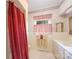 Bathroom with a red shower curtain, red and white checkered window treatment and tile flooring at 100 S Rudisill Ave, Cherryville, NC 28021