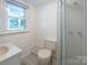A full, tiled bathroom featuring a modern shower and a window for natural light at 100 S Rudisill Ave, Cherryville, NC 28021