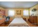 Sunny bedroom featuring hardwood floors, a ceiling fan, and two windows at 100 S Rudisill Ave, Cherryville, NC 28021