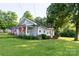 Quaint single-story home with a well-manicured lawn, front porch with rocking chairs, and mature trees at 100 S Rudisill Ave, Cherryville, NC 28021