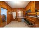 A spacious kitchen with rustic knotty pine walls, a bench, plenty of counter space, and natural light at 100 S Rudisill Ave, Cherryville, NC 28021