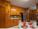 Cozy kitchen with wood-paneled walls, stainless steel refrigerator, and round breakfast table with colorful place settings at 100 S Rudisill Ave, Cherryville, NC 28021