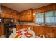 A kitchen nook features wood paneled walls, matching cabinets, and table set for a meal near the oven and sink at 100 S Rudisill Ave, Cherryville, NC 28021