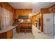 A spacious kitchen with rustic knotty pine walls, a bench, plenty of counter space, and stainless steel appliances at 100 S Rudisill Ave, Cherryville, NC 28021