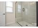 Modern bathroom featuring a glass-enclosed shower with a built-in bench and tiled walls at 1028 Grays Mill Rd, Charlotte, NC 28215