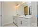Bathroom with double sink vanity, white cabinets, black hardware, and quartz countertop at 1028 Grays Mill Rd, Charlotte, NC 28215
