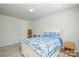 Comfortable bedroom with neutral walls, carpet, and a bed with blue patterned bedding at 1028 Grays Mill Rd, Charlotte, NC 28215